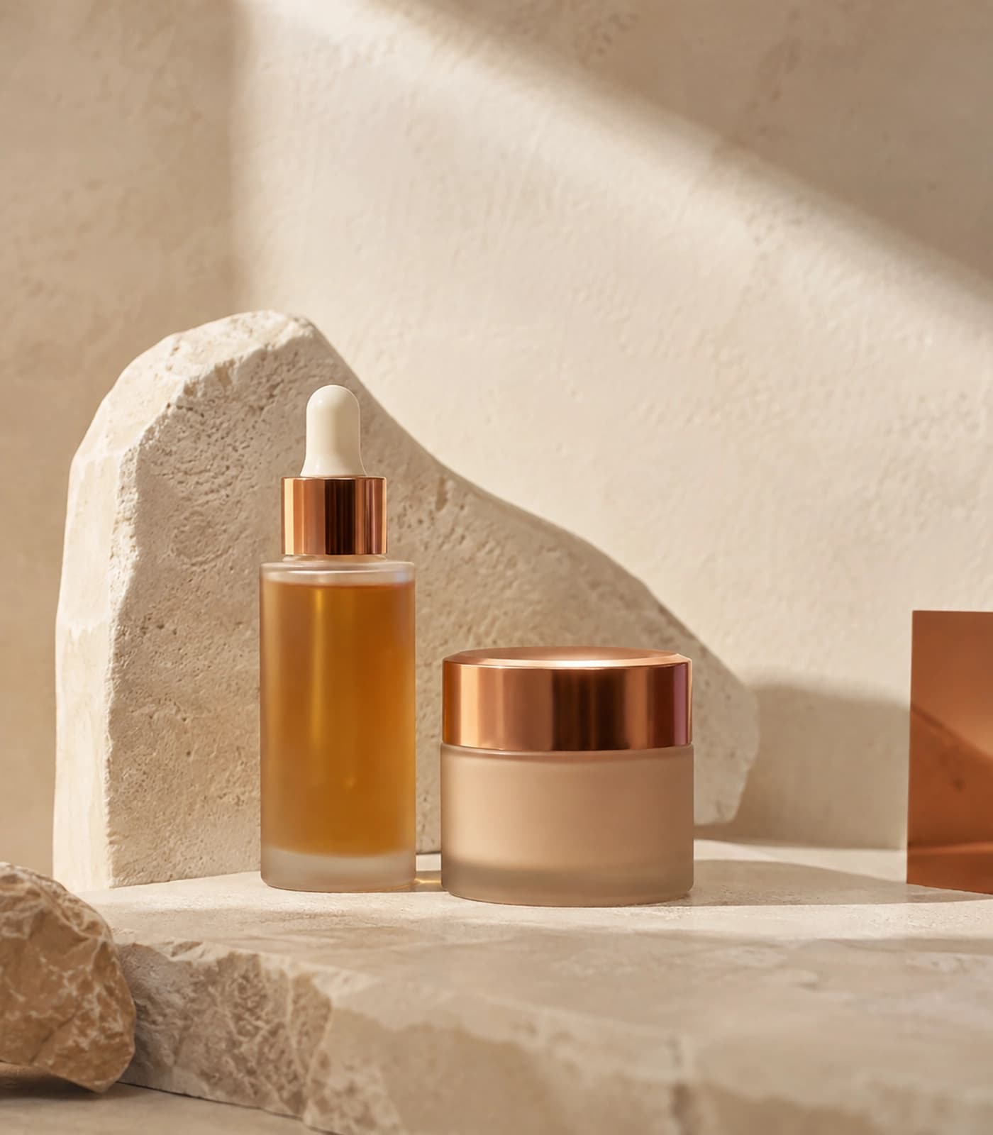 Bộ serum và kem dưỡng trong bố cục đá sáng và ánh nắng ấm